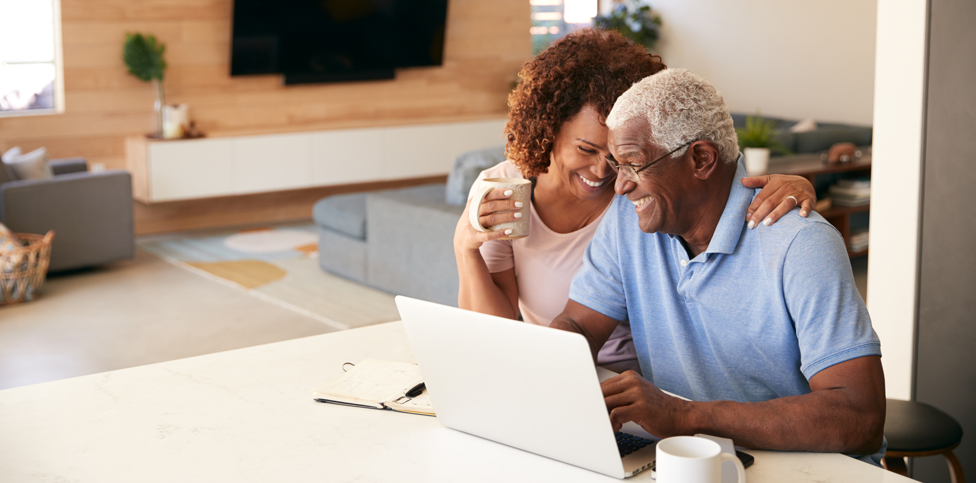 senior-african-american-couple-using-laptop-to-che-FEPS9LP